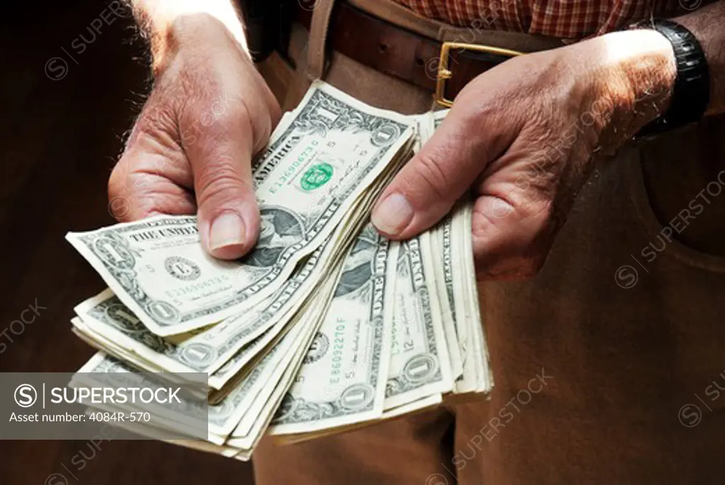 Older Man's Hands Holding Dollar Bills