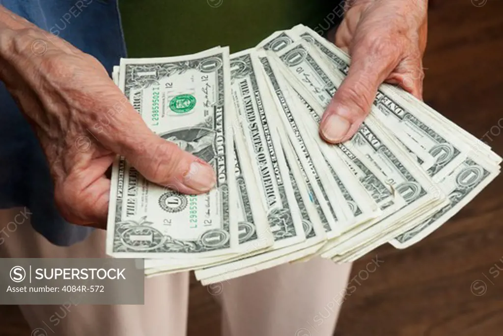 Older Man Handing Dollar Bills to Woman