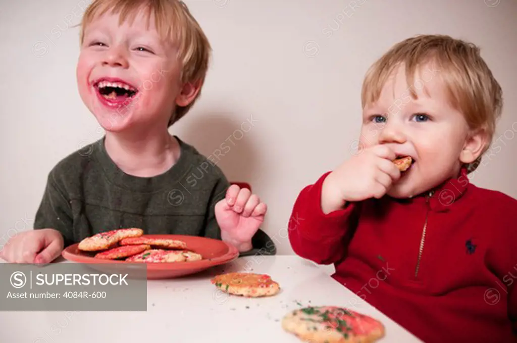 Two Happy Young Boys Eating Cookies