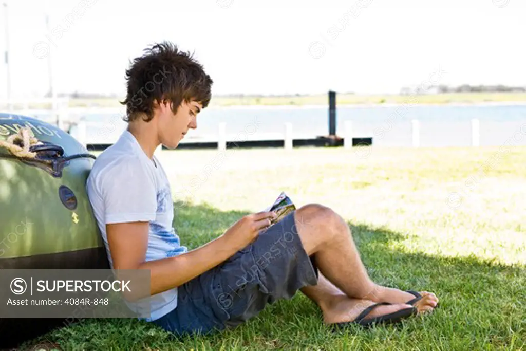 Young Man Leaning Against Boat, Reading