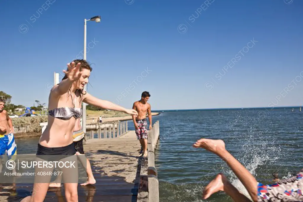 Woman Pushing Man into Water From Pier