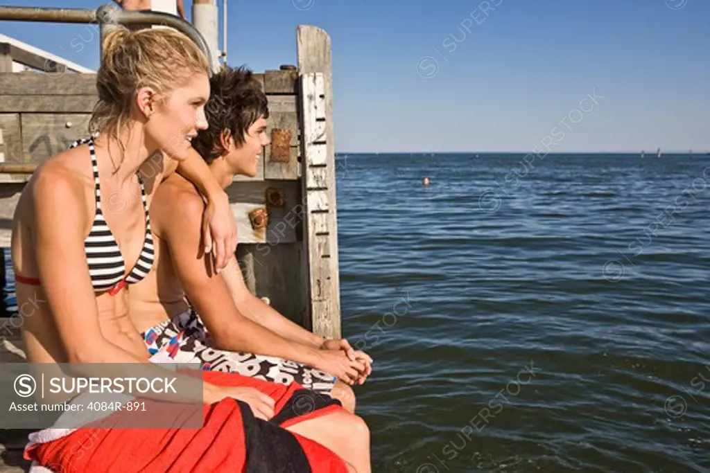 Young Couple Sitting on Edge of Pier