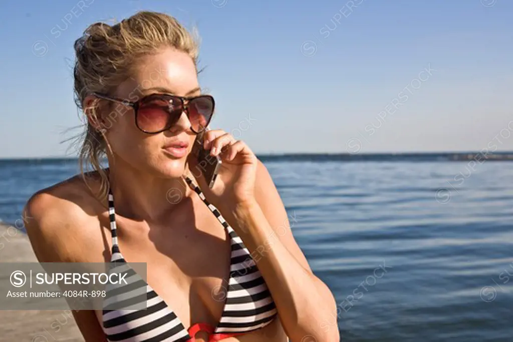 Young Woman Talking on Cell Phone on Pier
