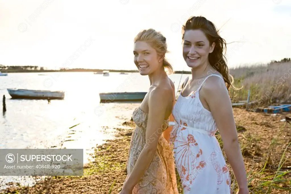 Two Smiling Young Women Standing on Shore