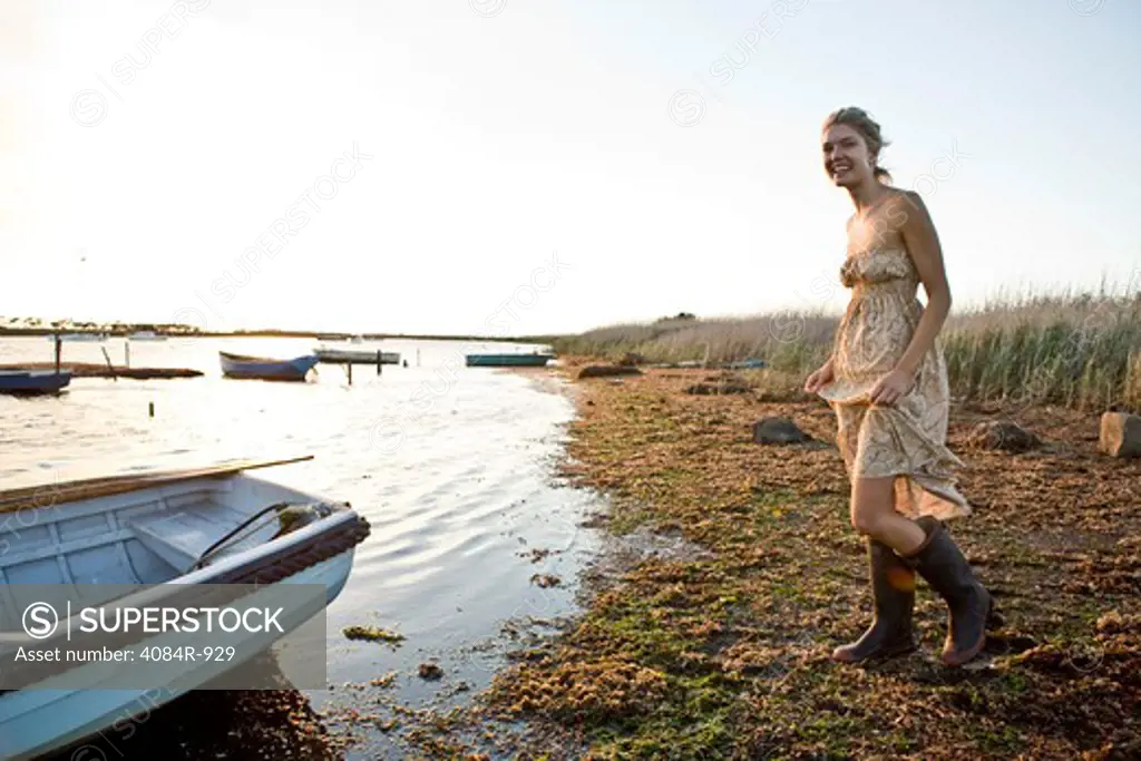Young Woman in Gum Boots Walking Along Shore
