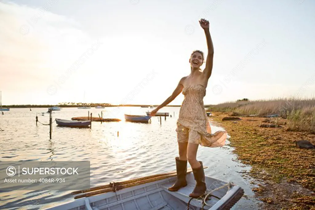 Smiling Young Woman in Gum Boots Balancing on Boat