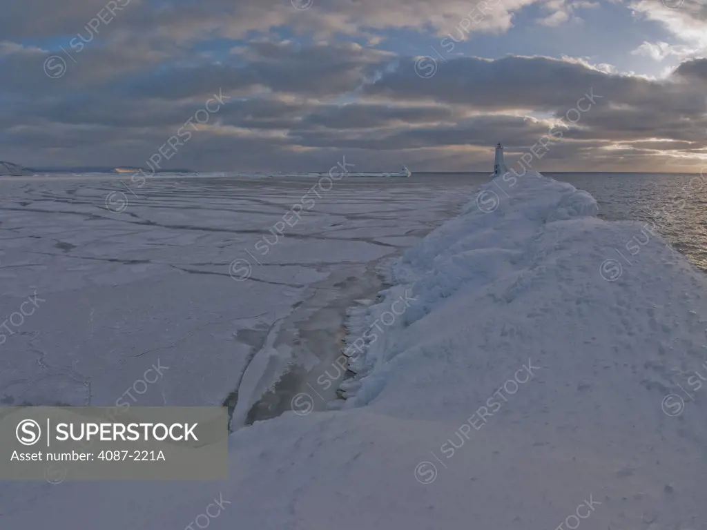 Frozen lake with a lighthouse in the background, Lake Michigan, Frankfort Lighthouse, Frankfort, Benzie County, Michigan, USA