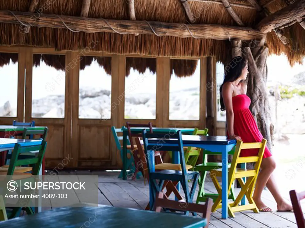 Young woman leaning against a table in a restaurant, La Palapa, Tulum, Mexico