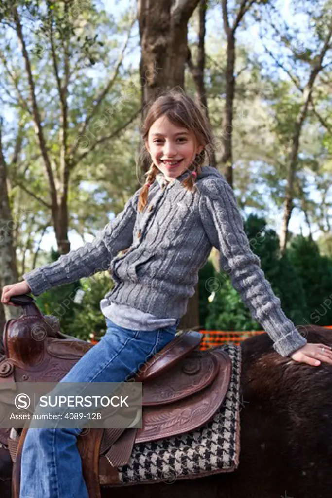 Girl riding horse at a petting zoo