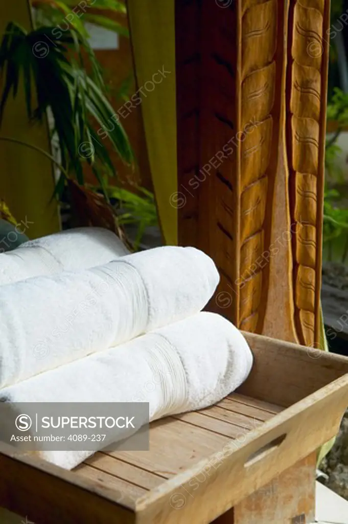Close-up of rolled up white towels on a tray at a spa