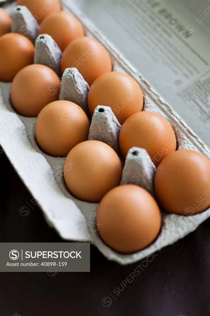 Close-up of brown eggs in carton