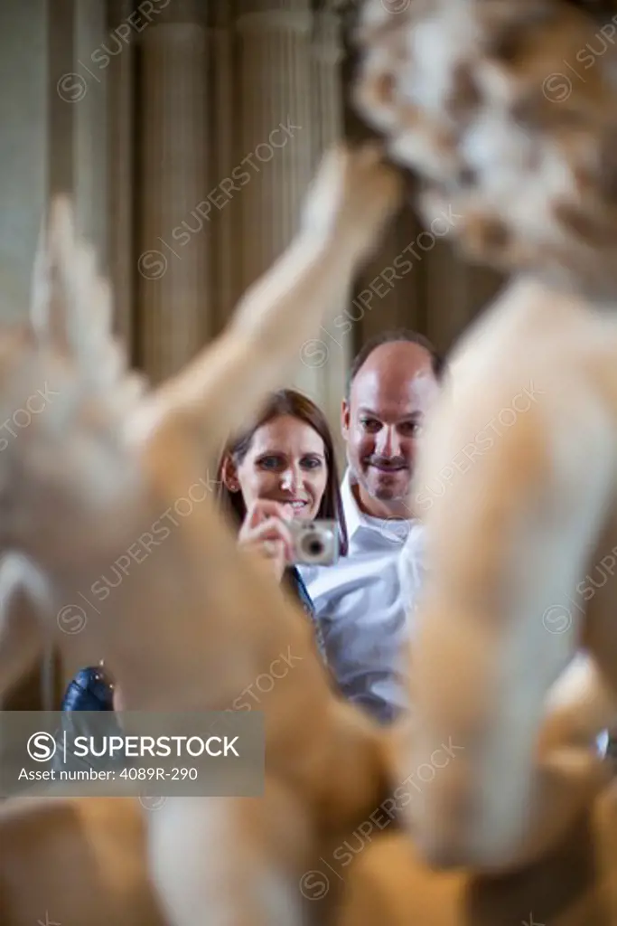 Couple taking picture of a statue in a museum