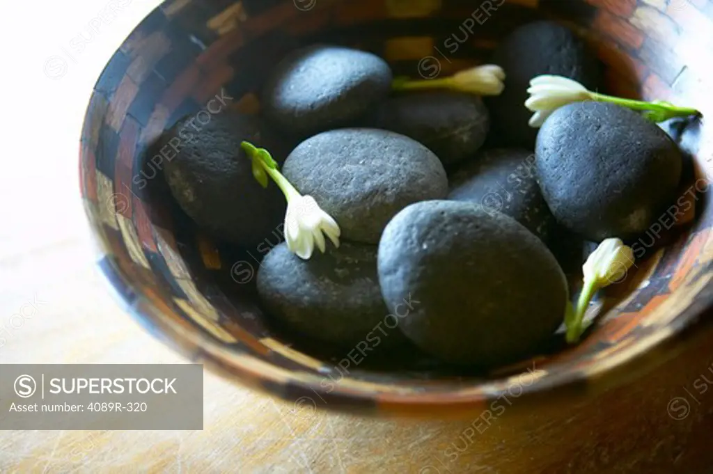 Stones and tuberose flowers in bowl