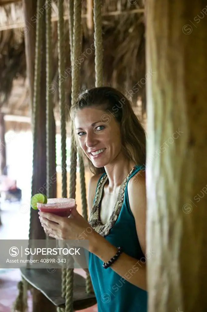 Mexico, Portrait of woman holding margarita and smiling
