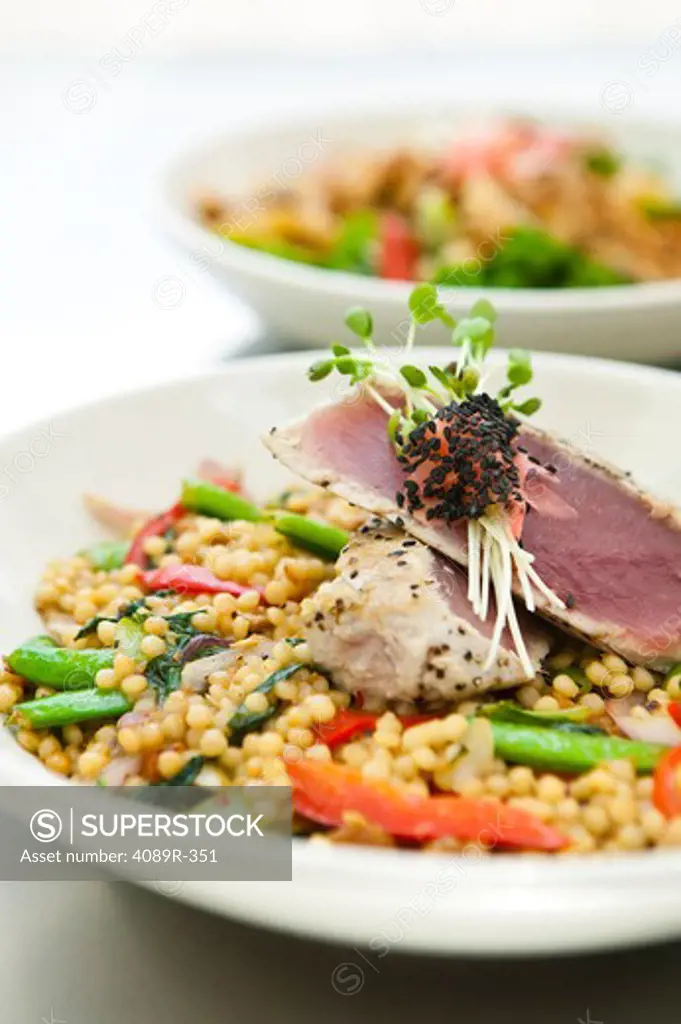 Stir-fried pearl past with vegetables and yellowfintuna with sprouts, studio shot