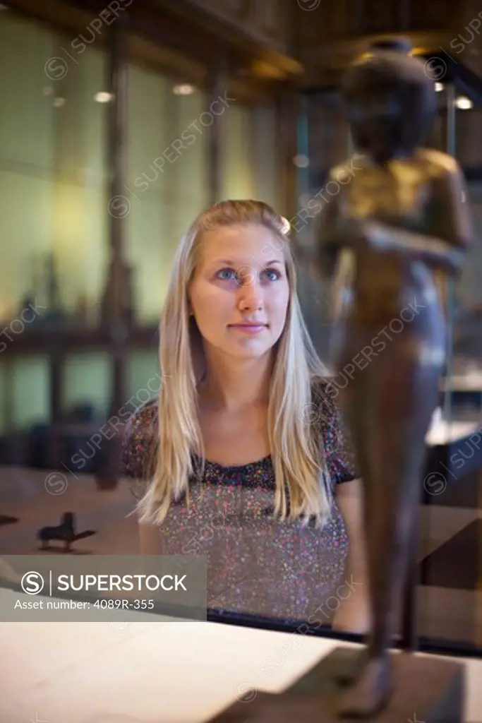 Teenage girl watching Egyptian relics in a museum, Paris, Ile-de-France, France