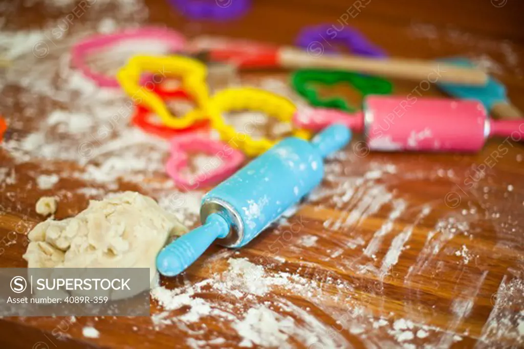 Close up of tray with flour, rolling pins and cookie cutters