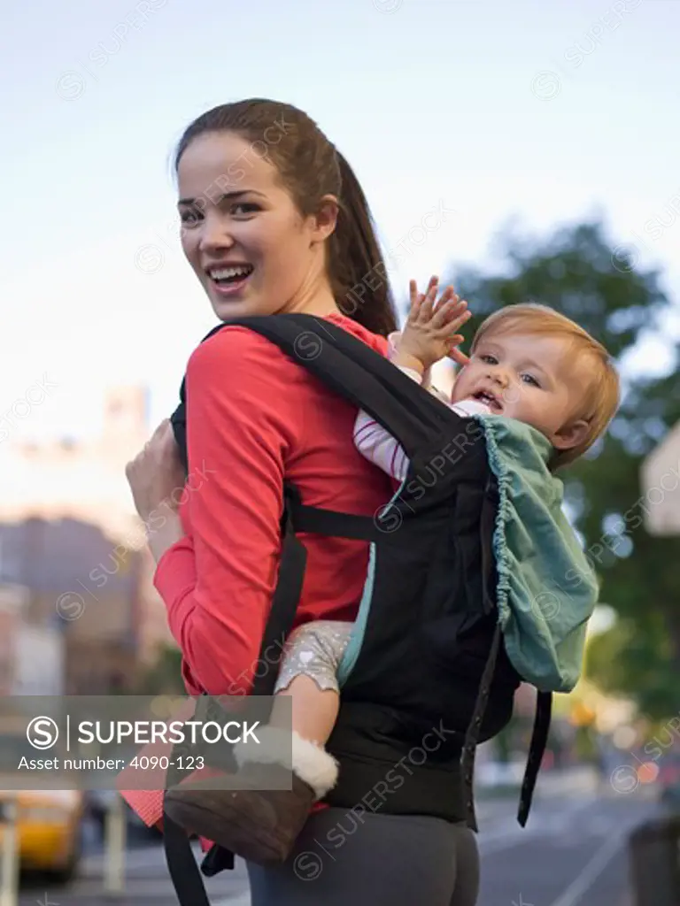 Young woman carrying her baby in a baby carrier, New York City, New York State, USA