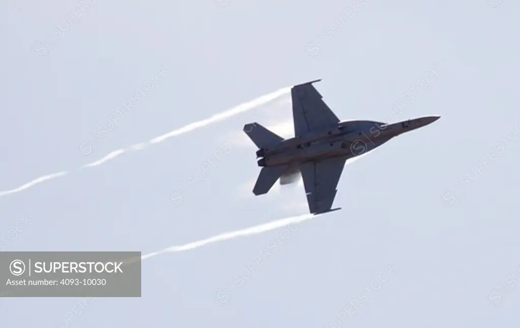 A Boeing F-18 Super Hornet performing a high speed pass at the Watsonville, CA airshow. The Boeing F/A-18F Super Hornet is a carrier-based strike fighter aircraft. The Super Hornet has an internal 20 mm gun and can carry various air-to-air missiles and air-to-surface weapons.   Designed and initially produced by McDonnell Douglas, the Super Hornet first flew in 1995.