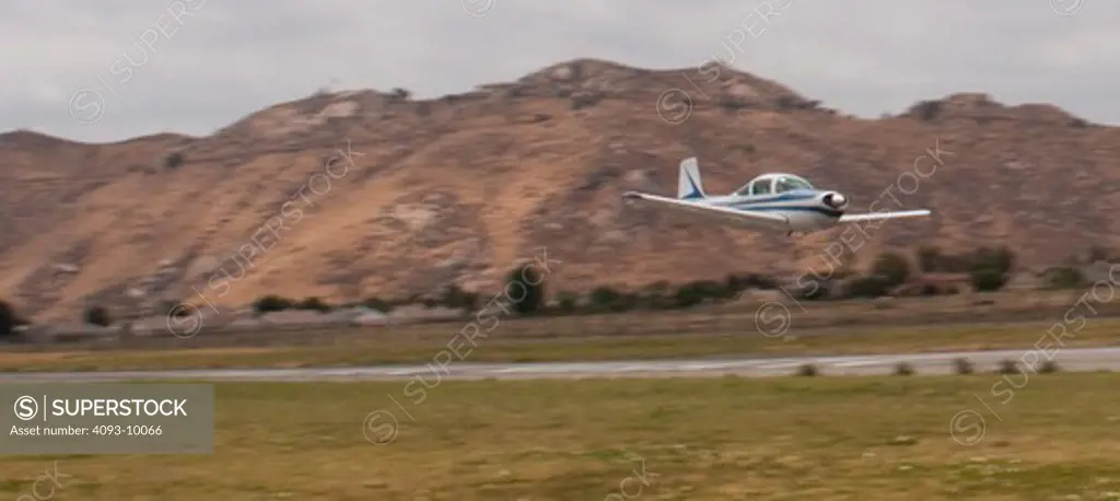 A Meyers 200D performing a low pass at Flabob Airport in Riverside, CA.  The Meyers 200 is a single engine piston airplane and was designed by Al Meyers in the late 1950's and built by the Meyers Aircraft Company until 1965. Aero Commander then built them until 1967. It has a cruise speed of 210 mph and is considered one of the fastest airplanes in it's class.