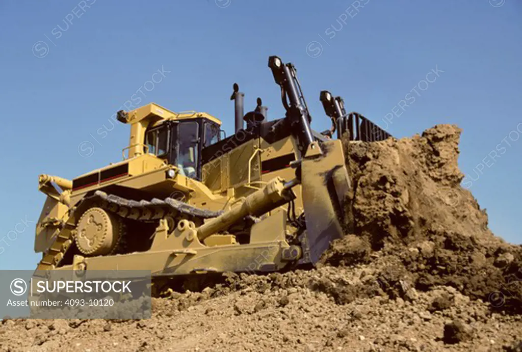 low angle bulldozer earth mover yellow rocks