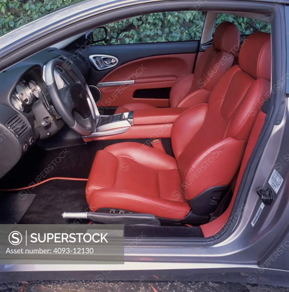interior detail Aston Martin Vanquish 2003 red leather seats emergency brake steering wheel