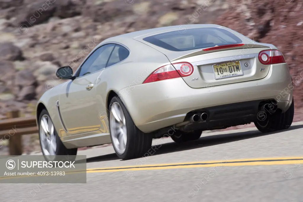 2008 Jaguar XKR driving on road, rear view
