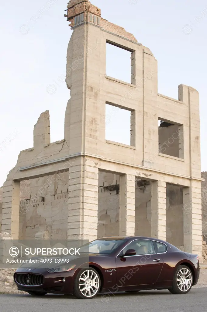 Maserati GranTurismo parked by dilapidated building