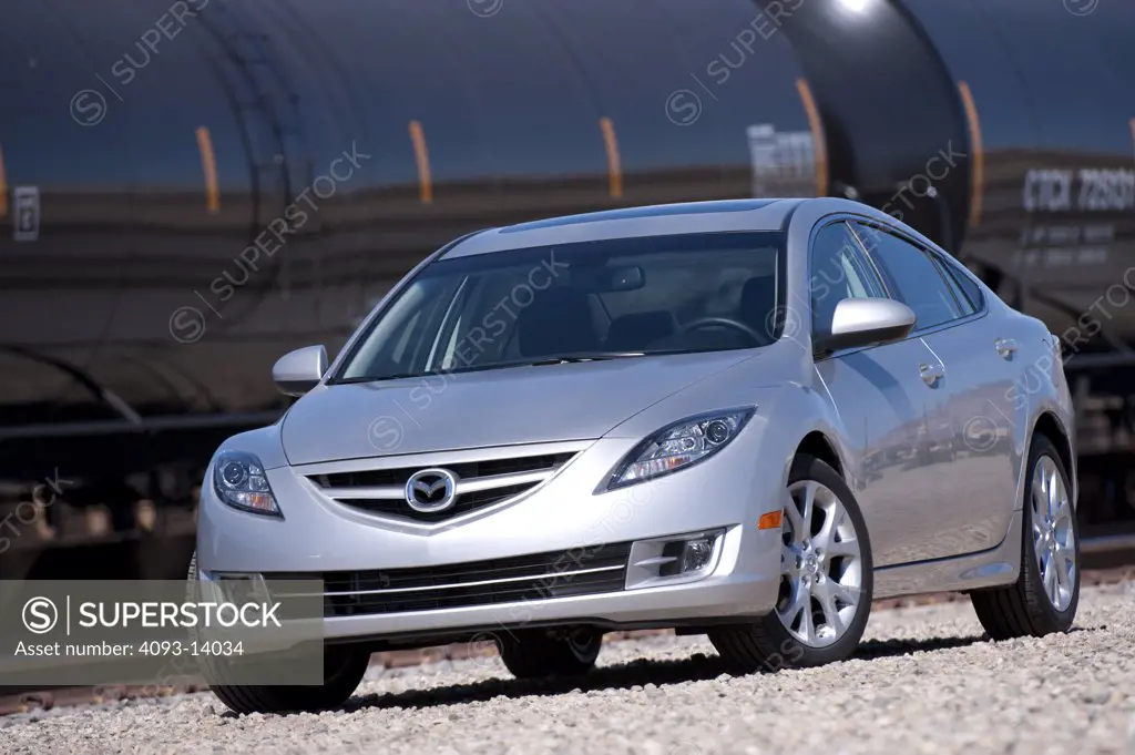 Silver Mazda 6 parked by goods train
