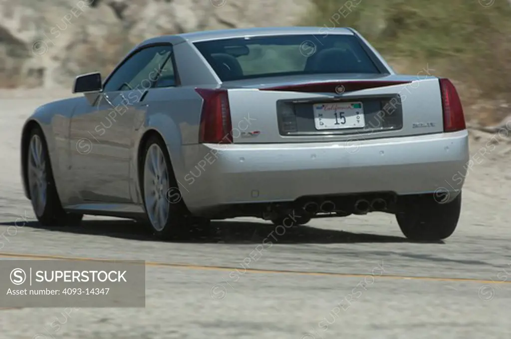 Cadillac XLR-V driving along desert road, rear view