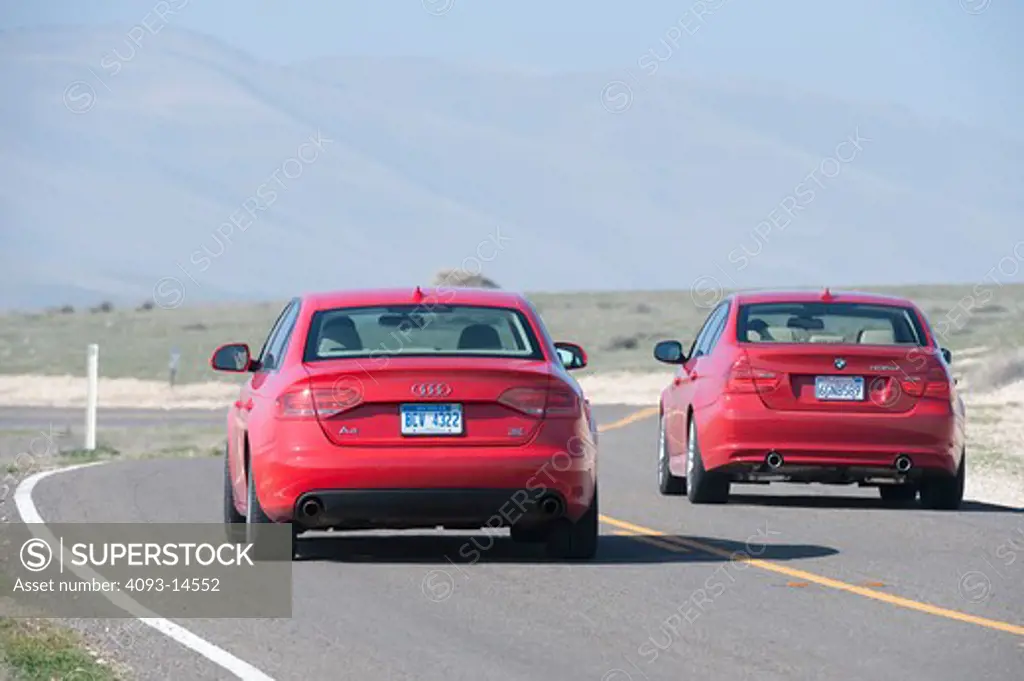 2009 BMW 335d and 2009 Audi A4 on the road, rear view