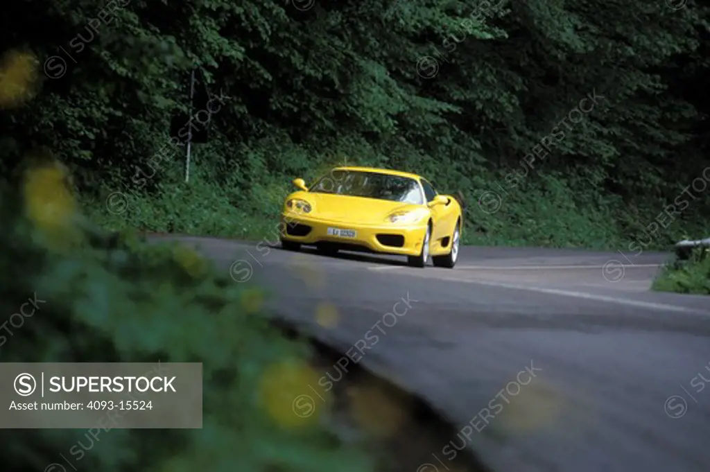 Ferrari 1999 360 Modena yellow front 3/4 asphalt trees dappled light wildflowers beauty 1990s street