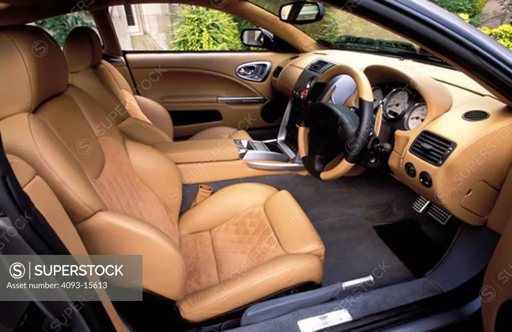 interior Aston Martin 2002 Vanquish tan leather front seat emergency brake right hand drive dashboard gauges speedometer air vents steering wheel detail city