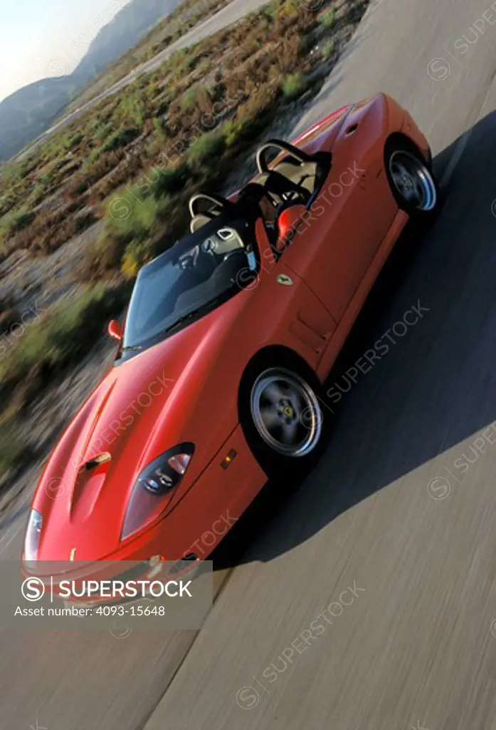 Ferrari 2002 550 Barchetta Pininfarina red front 3/4 man asphalt brush curve street