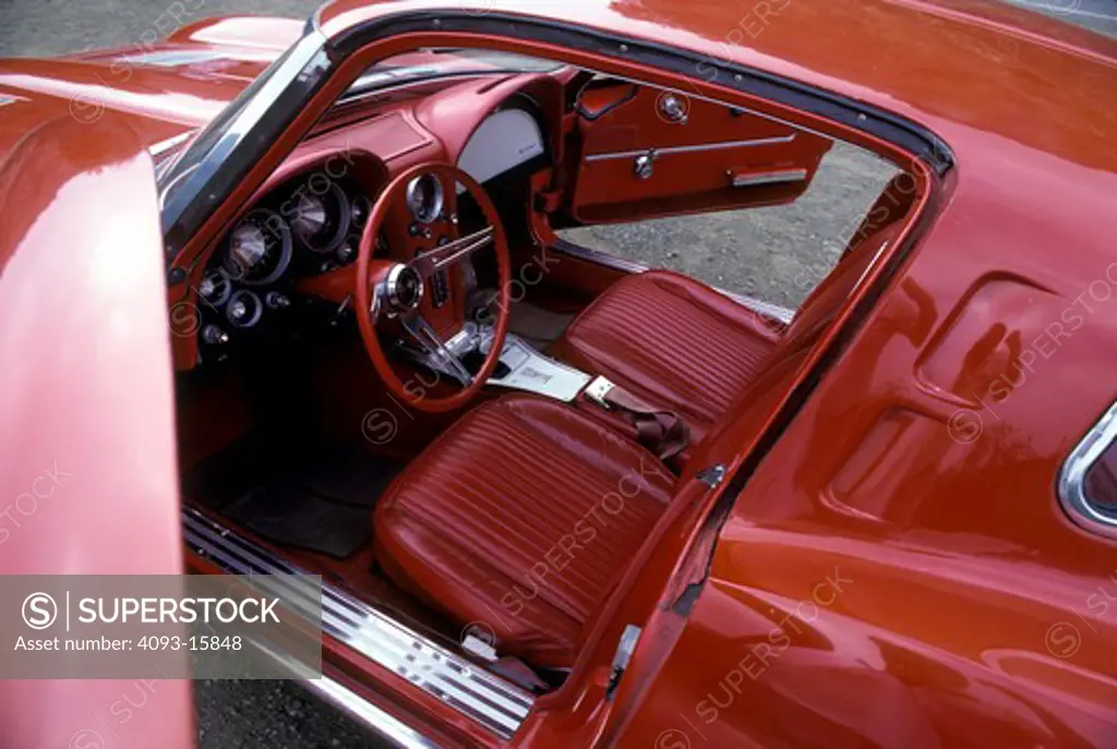 interior detail Corvette Stingray 1963 1960s red Chevy open door seat.steering wheel gauges