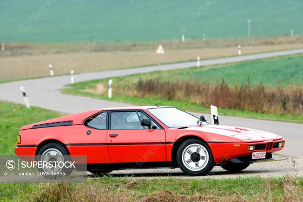 1978 red BMW M1 front 7/8 image on rural road in Germany. The BMW M1 is a supercar produced by the German automaker BMW from 1978 to 1981. It was the first and only mid-engined BMW. It employed a twin-cam M88/1 3.5 L 6-cylinder gasoline engine. The M1 coupe was hand-built between 1978 and 1981 under the Motorsport division of BMW as a homologation special for sports car racing. The body was designed by Giugiaro.