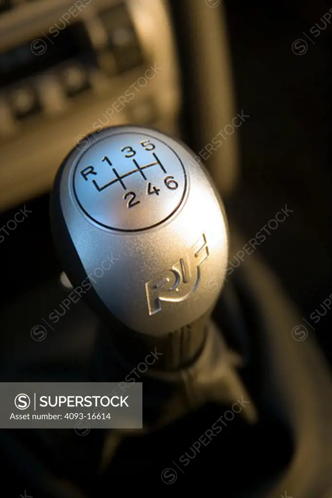 Interior detail view of a 2007 Ruf Porsche RT12 showing the 6-speed metal shifter with the Ruf logo. introduced the model in Fall 2004 at the Essen Motor Show as the first of their offerings built on Porsche's new 997 platform. A twin-turbocharged, 3.6 litre flat-six cylinder engine based on the previous 996 series Turbo engine provides 530 and 560 Bhp options while the bored-out 3.8 litre option produces 650 bhp. The Rt 12 features specially developed RUF bodywork, giving the vehicle a unique a