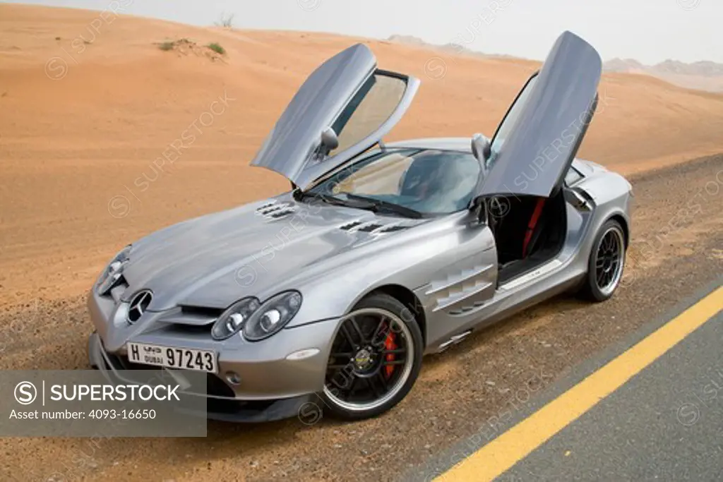 A front 3/4 view of the 2007 Mercedes-Benz McLaren SLR 722 with the unusual gull-wing doors open. The 722 refers to the victory by Stirling Moss and his co-driver Denis Jenkinson in a Mercedes-Benz 300 SLR with the starting number 722 (indicating a start time of 7:22 a.m.) at the Mille Miglia in 1955. The 722 Edition creates 650 bhp, with a top speed of 337 km/h (5 more than the standard SLR). A new suspension is used with 19-inch light-alloy wheels, a stiffer damper configuration and 0.4 inches