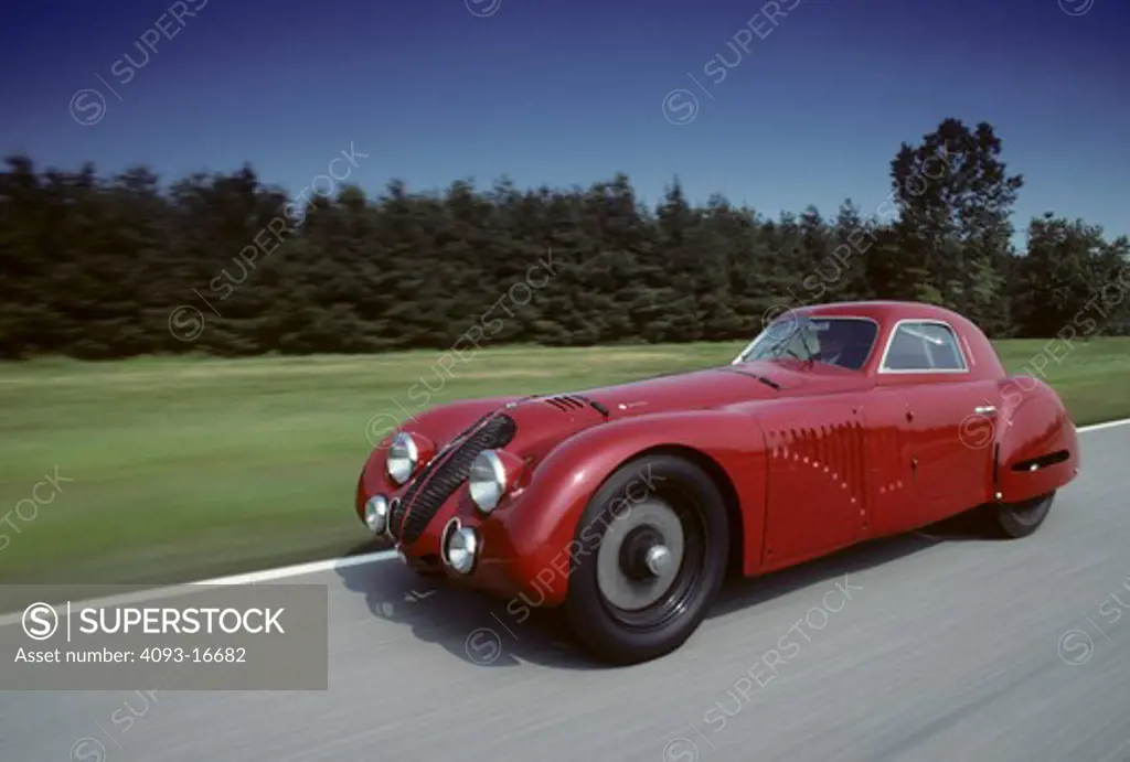 1938 Alfa Romeo 8C 2900B Touring Coupe action front 3/4. The rare and unique Alfa Romeo 8C 2900 B was designed in the 1930's for both racing and road use. It featured a 180 bhp version of the famous 8 cylinder Alfa Romeo engine originally designed by Vittorio Jano. This engine was installed in a box-type chassis available in short and long wheel base configurations, both with all-round independent suspension. Most of the 33 8C 2900Bs built were fitted with lightweight Touring bodies, constructed