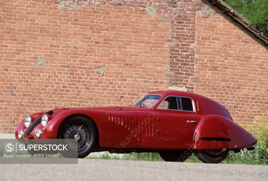 1938 Alfa Romeo 8C 2900B Touring Coupe beauty front 3/4 profile. The rare and unique Alfa Romeo 8C 2900 B was designed in the 1930's for both racing and road use. It featured a 180 bhp version of the famous 8 cylinder Alfa Romeo engine originally designed by Vittorio Jano. This engine was installed in a box-type chassis available in short and long wheel base configurations, both with all-round independent suspension. Most of the 33 8C 2900Bs built were fitted with lightweight Touring bodies, con