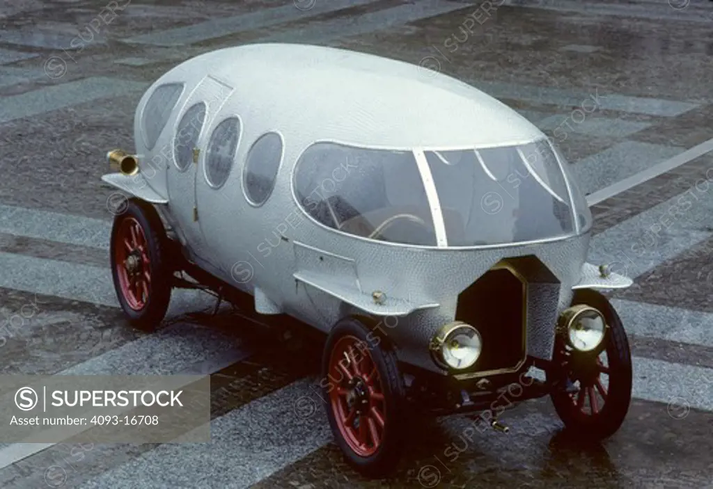 1914 Alfa Romeo Ricotti vintage Raindrop front 3/4 beauty. The A.L.F.A 40/60 HP was race and road car made by Italian car manufacturer A.L.F.A (later called Alfa Romeo). In 1914 Marco Ricotti from Carrozzeria Castagna designed A.L.F.A. 40/60 HP Aerodinamica prototype model which could reach 139 km/h top speed. out front a commercial building
