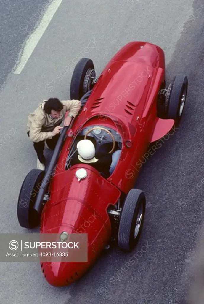 1957 Maserati 250F race car beauty static overhead people. The Maserati 250F (first raced January 1954 - last raced November 1960) was a racing car made by Maserati of Italy, used in '2.5 litre' Formula One racing (thus, the '250' and 'F'). 26 examples were made in total. It was introduced for the 1954 Formula One season and remained in use by customer teams until 1960.  The Maserati is on the old Reims race track. Between 1925 and 1969, Reims hosted the Grand Prix de la Marne automobile race