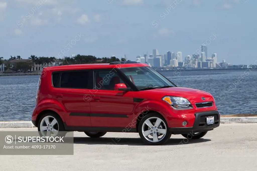 Front 3/4 static view of a 2010 red Kia Soul at the beach