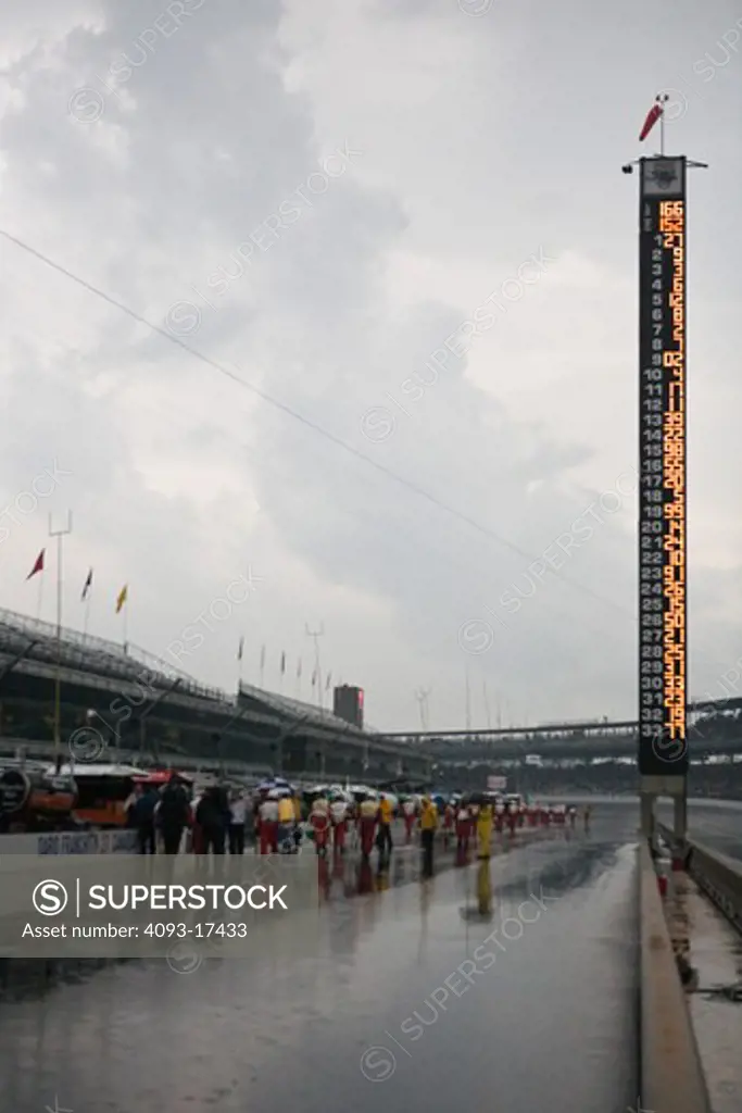 placement ranking sign at a race racetrack getting rained out at the Indy 500 people walking with umbrellas