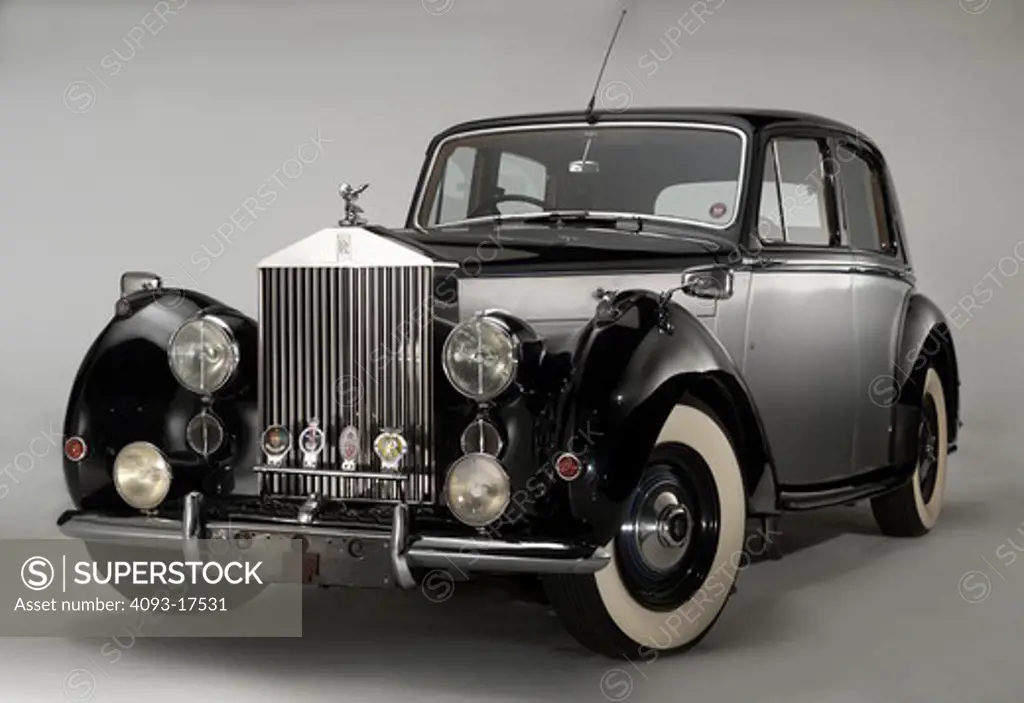 Front 3/4 view of a black and silver 1949 Rolls Royce Silver Dawn photographed on a white background.