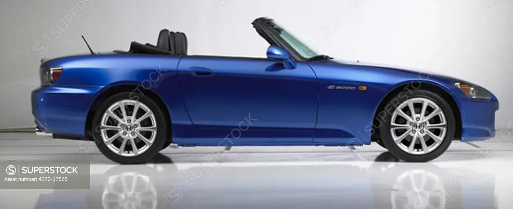Profile view of a blue 2007 Honda S2000 sports car photographed in the studio with a white background.