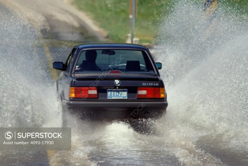 BMW 318is 3 Series 1990s black splash water spray low water crossing street