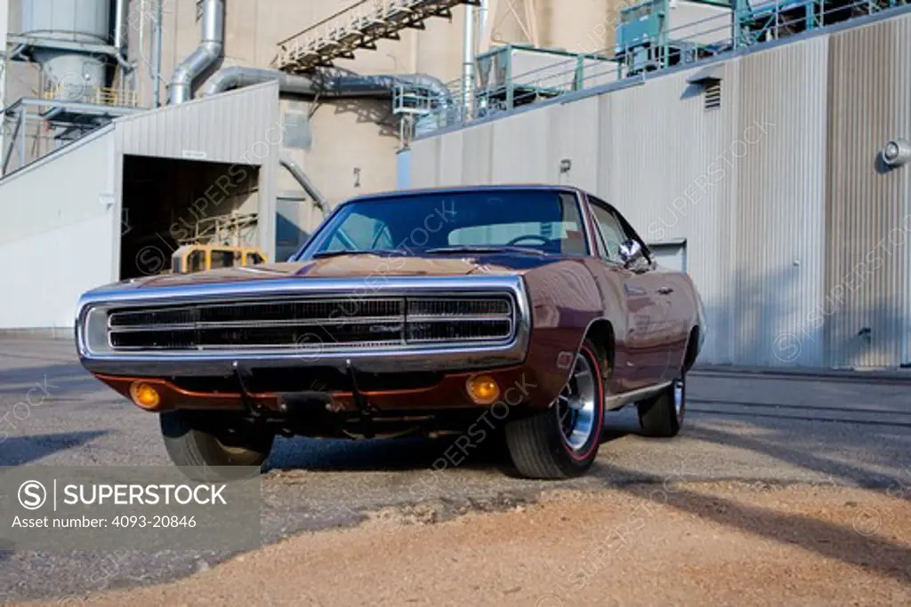 1970 red maroon 383 Dodge Charger next to a factory