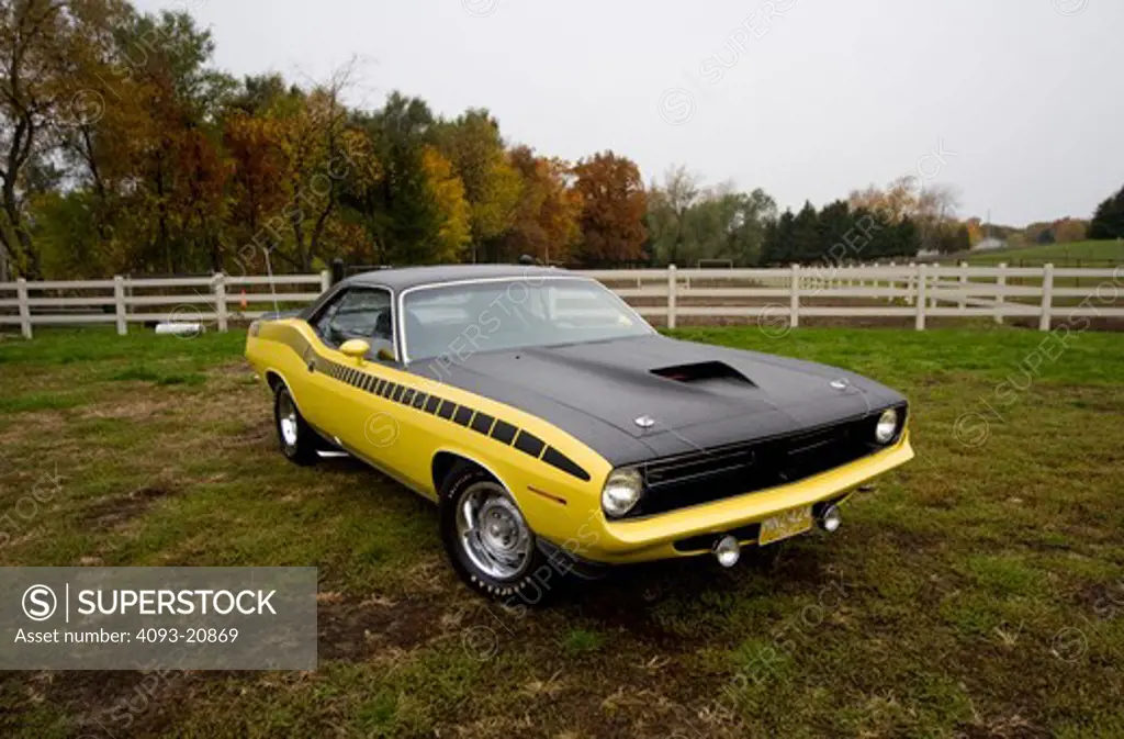 1970 plymouth AAR barracuda in the country on a rainy day.