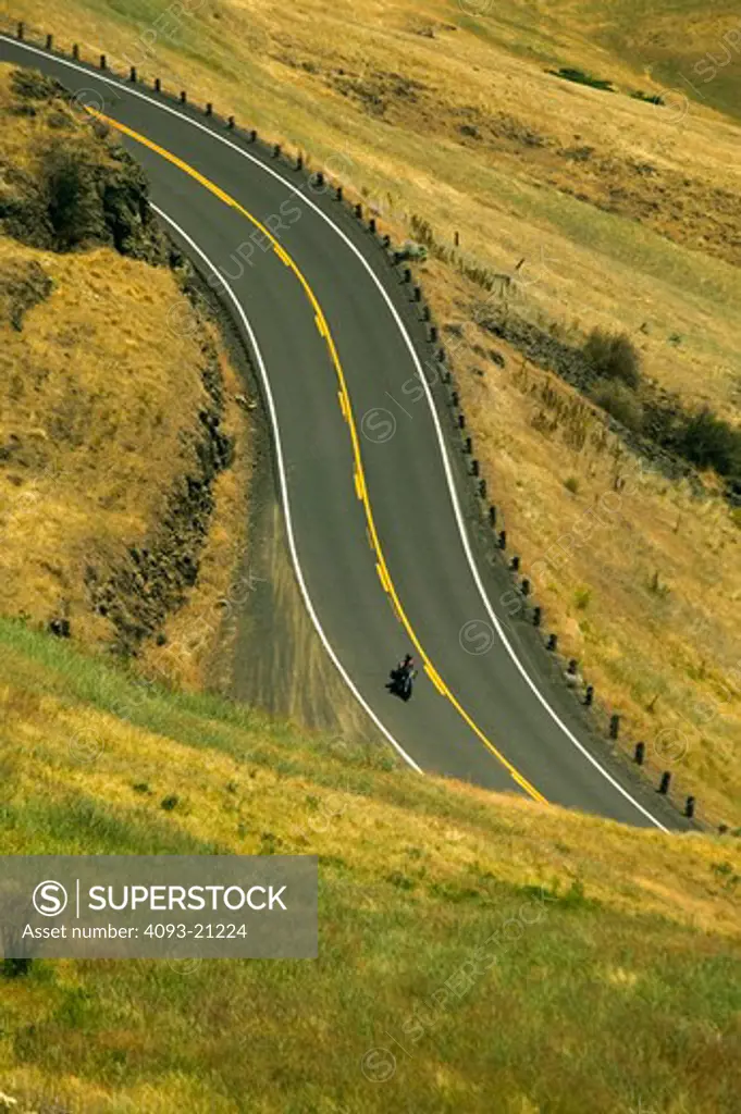 A single motorcycle, spiral highway twisty roads
